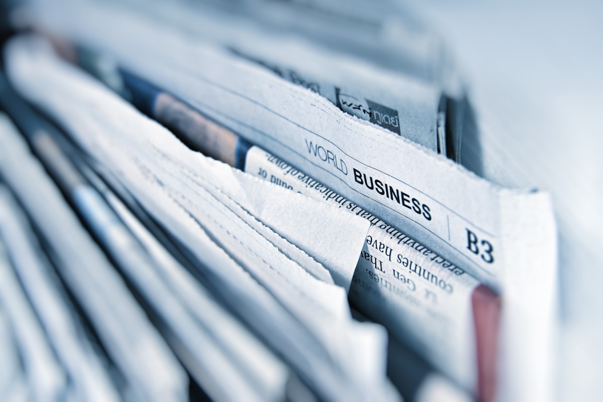 「WORLD BUSINESS」と書かれた新聞の束